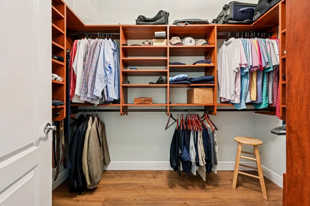 a view of walk in closet with clothes and shoes