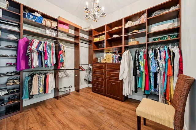 a view of walk in closet with clothes and shoes