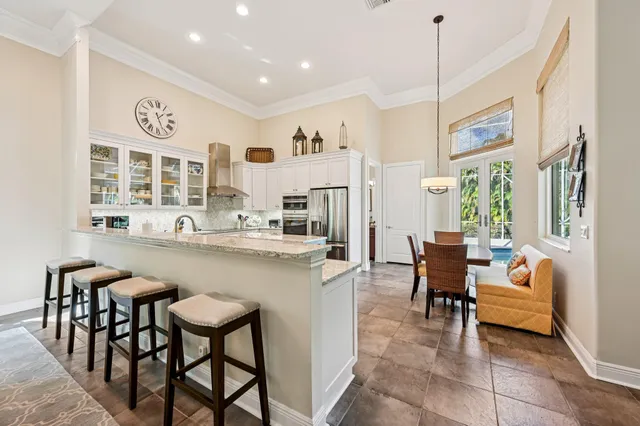 a view of a dining room with furniture a kitchen and chandelier