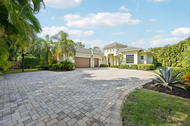 a front view of a house with a yard and potted plants