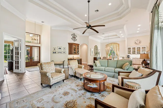 a living room with furniture kitchen view and a chandelier