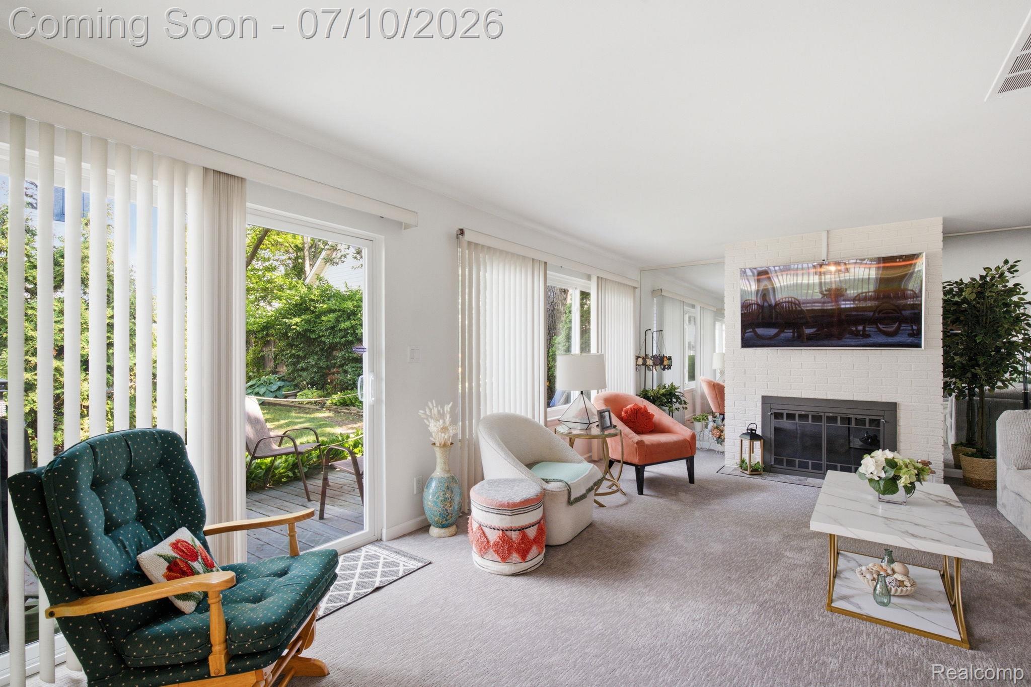 1501 River Road, Unit 301 St. Clair, MI 48079 - Photo 13 of 32 Spacious living area featuring light-colored carpeting, a white brick fireplace surround, and multiple sliding glass doors