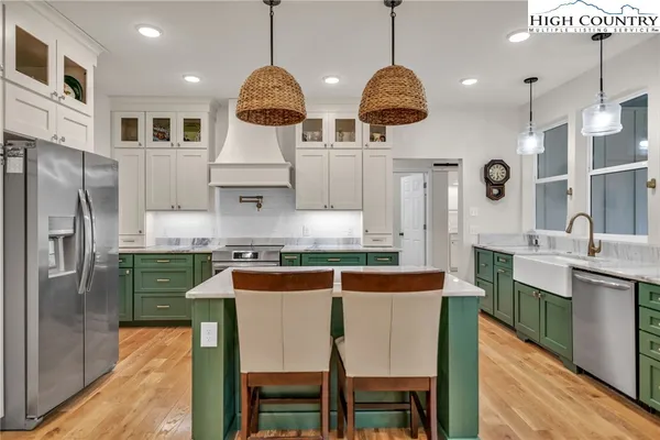 a kitchen with stainless steel appliances granite countertop a sink a stove and a refrigerator