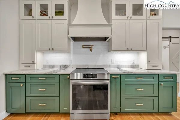 a kitchen with granite countertop a stove and cabinets