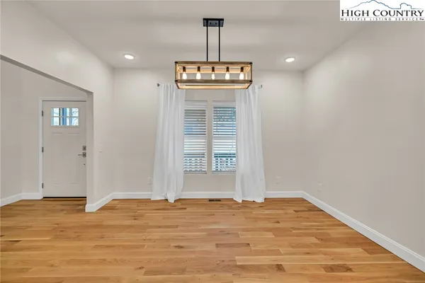 a view of a livingroom with wooden floor and a window