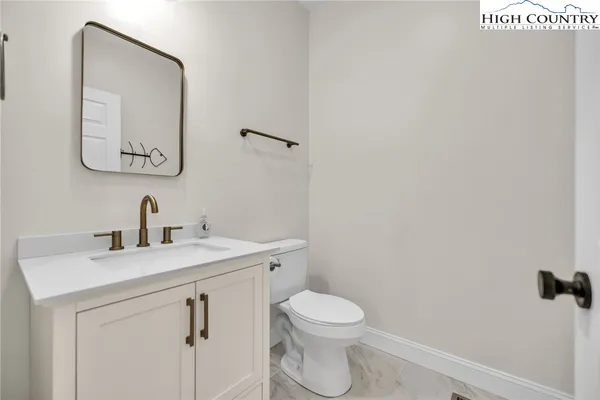 a bathroom with a toilet sink vanity and mirror