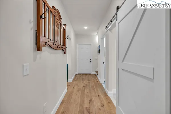 a view of a hallway with wooden floor and staircase