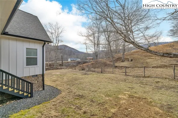 a view of a yard with wooden fence