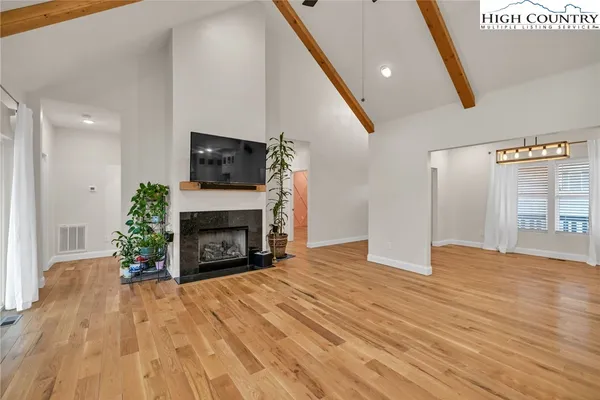 a view of empty room with wooden floor and fireplace