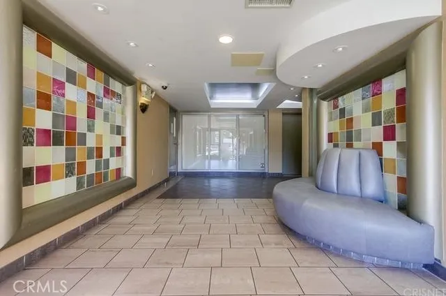 a hall with a couch and a large window