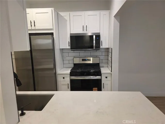 a kitchen with stainless steel appliances a refrigerator a stove and a microwave