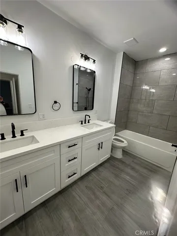 a spacious bathroom with a double vanity sink a large mirror and shower