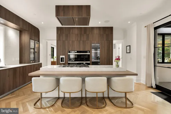 a kitchen with kitchen island a dining table and chairs