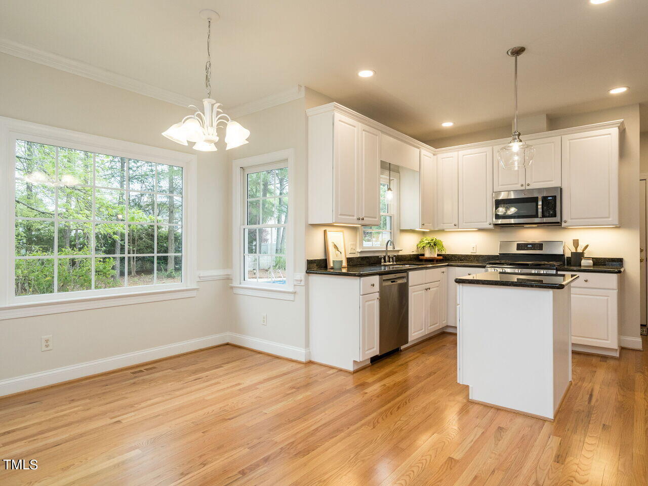 760 Hadrian Drive Garner, NC 27529 - Photo 12 of 38 a kitchen with stainless steel appliances granite countertop a refrigerator a stove top oven a sink dishwasher and white cabinets with wooden floor