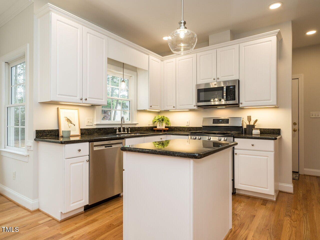 760 Hadrian Drive Garner, NC 27529 - Photo 14 of 38 a kitchen with kitchen island granite countertop a sink cabinets and wooden floor