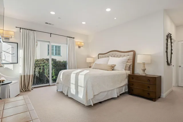 a spacious bedroom with a bed a couch and a window