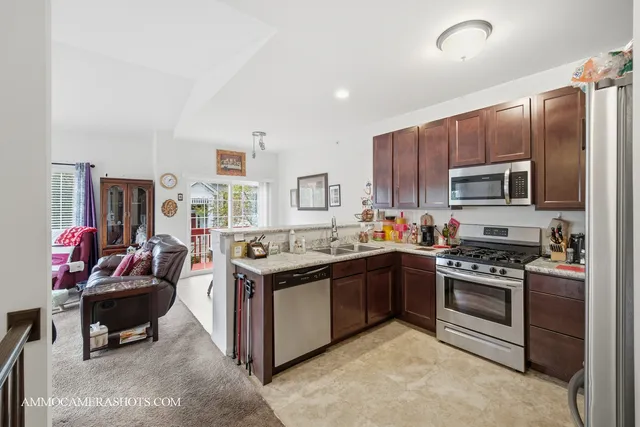 a kitchen with stainless steel appliances granite countertop a stove top oven a sink and dishwasher