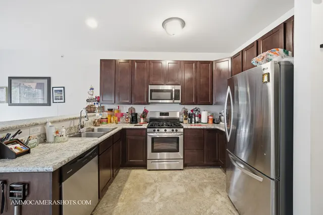 a kitchen with stainless steel appliances granite countertop a refrigerator stove and sink