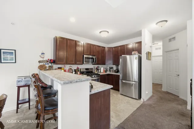 a kitchen with refrigerator and chairs