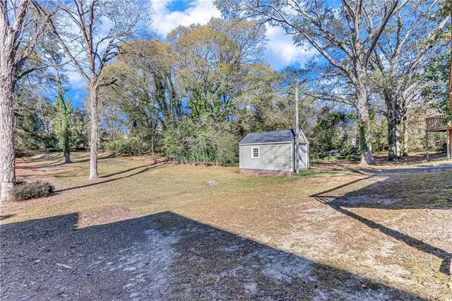 a view of green field with trees in the background