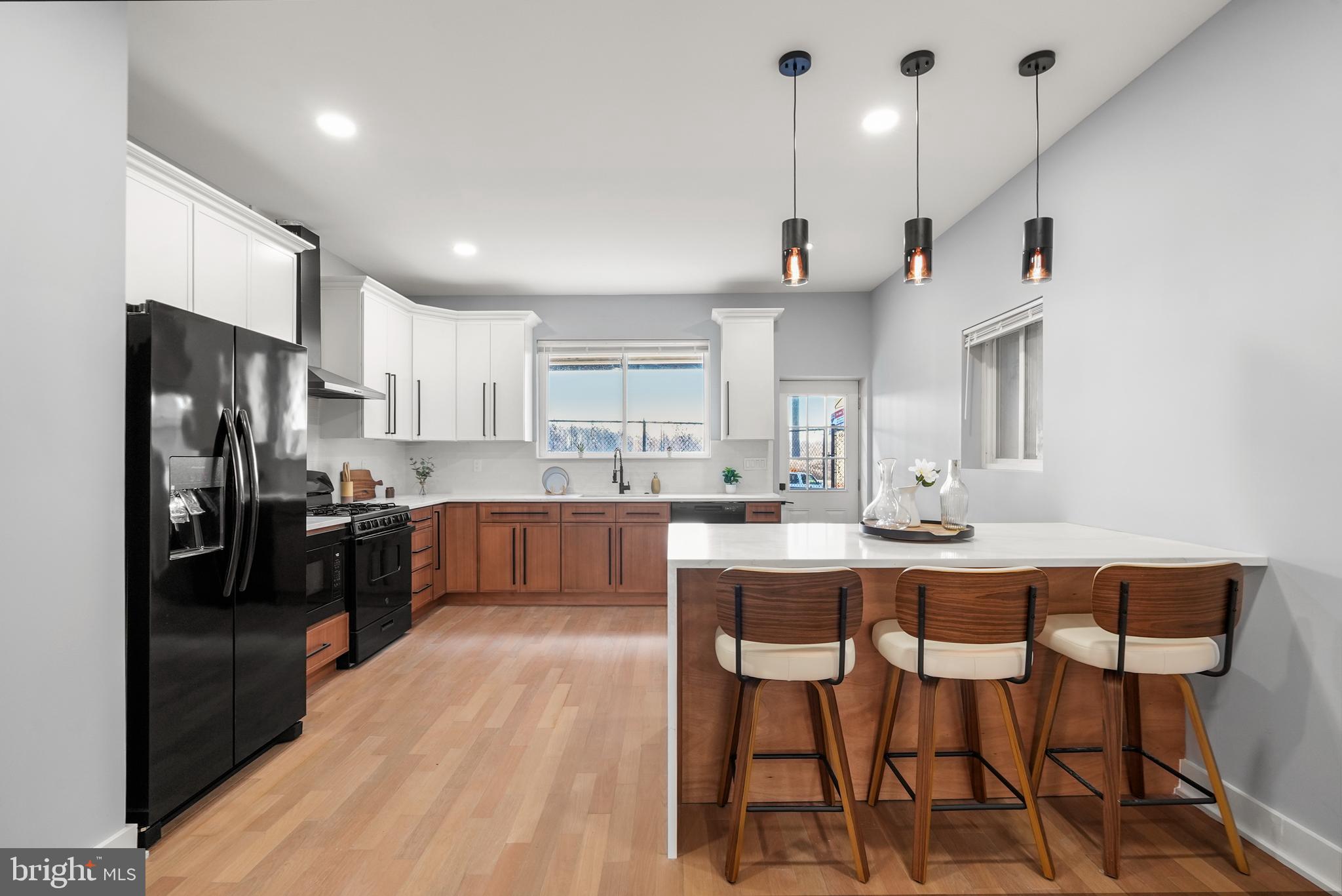 2811 Salmon Street Philadelphia, PA 19134 - Photo 1 of 25 a kitchen with stainless steel appliances kitchen island granite countertop a dining table chairs and refrigerator