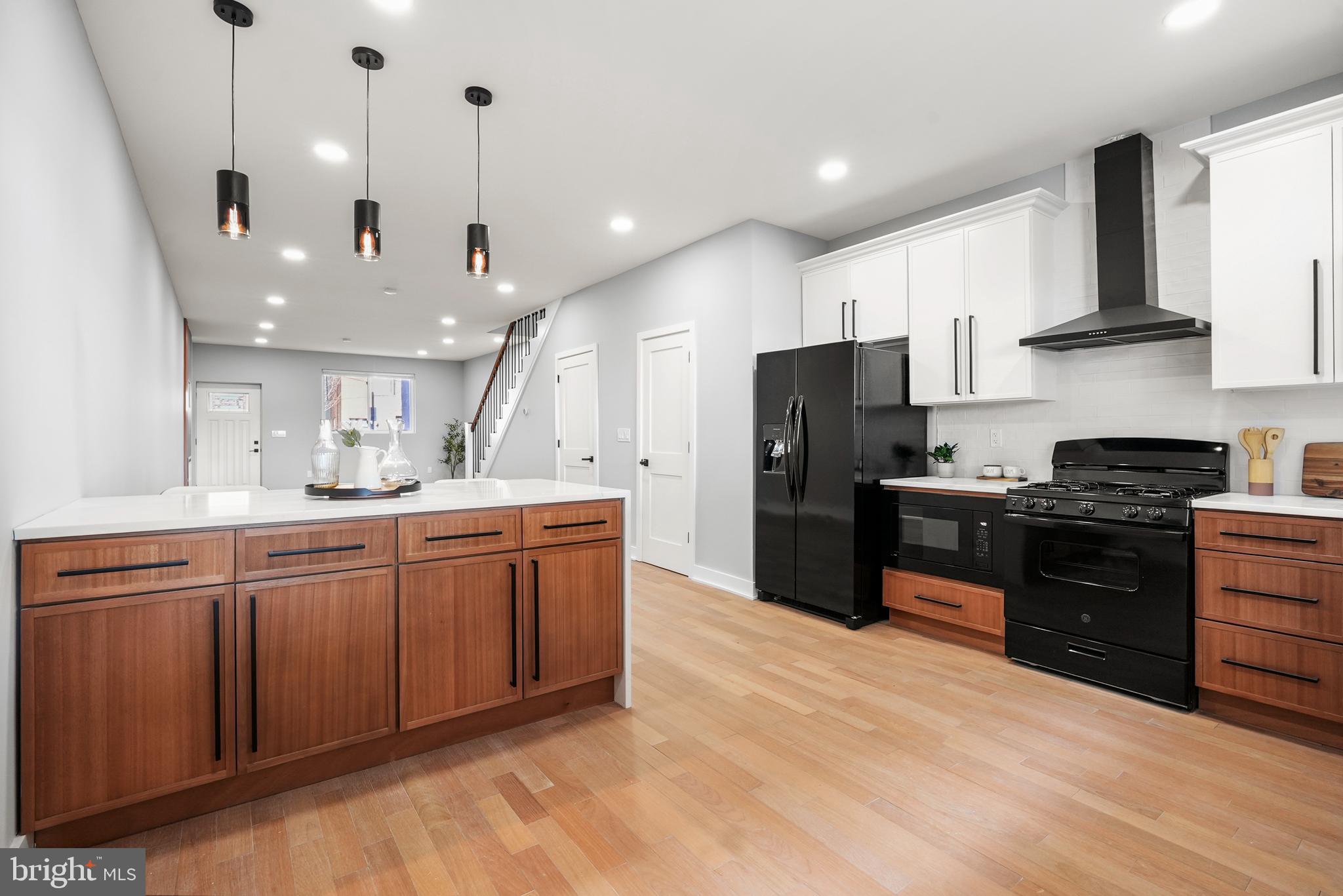 2811 Salmon Street Philadelphia, PA 19134 - Photo 5 of 25 a kitchen with stainless steel appliances granite countertop a refrigerator a sink dishwasher a stove and a oven with wooden floor