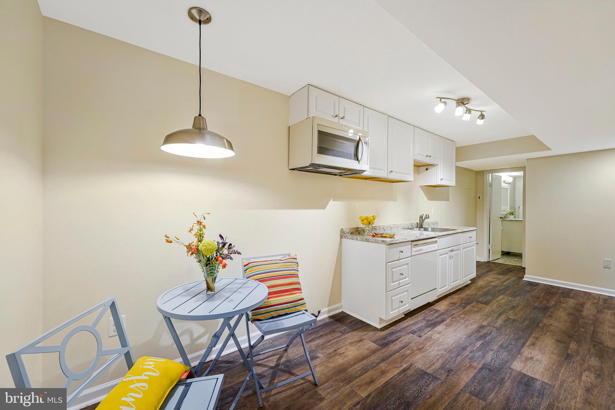 8230 Citadel Place Vienna, VA 22180 - Photo 23 of 38 a kitchen with stainless steel appliances a stove a chandelier chandelier and wooden floor