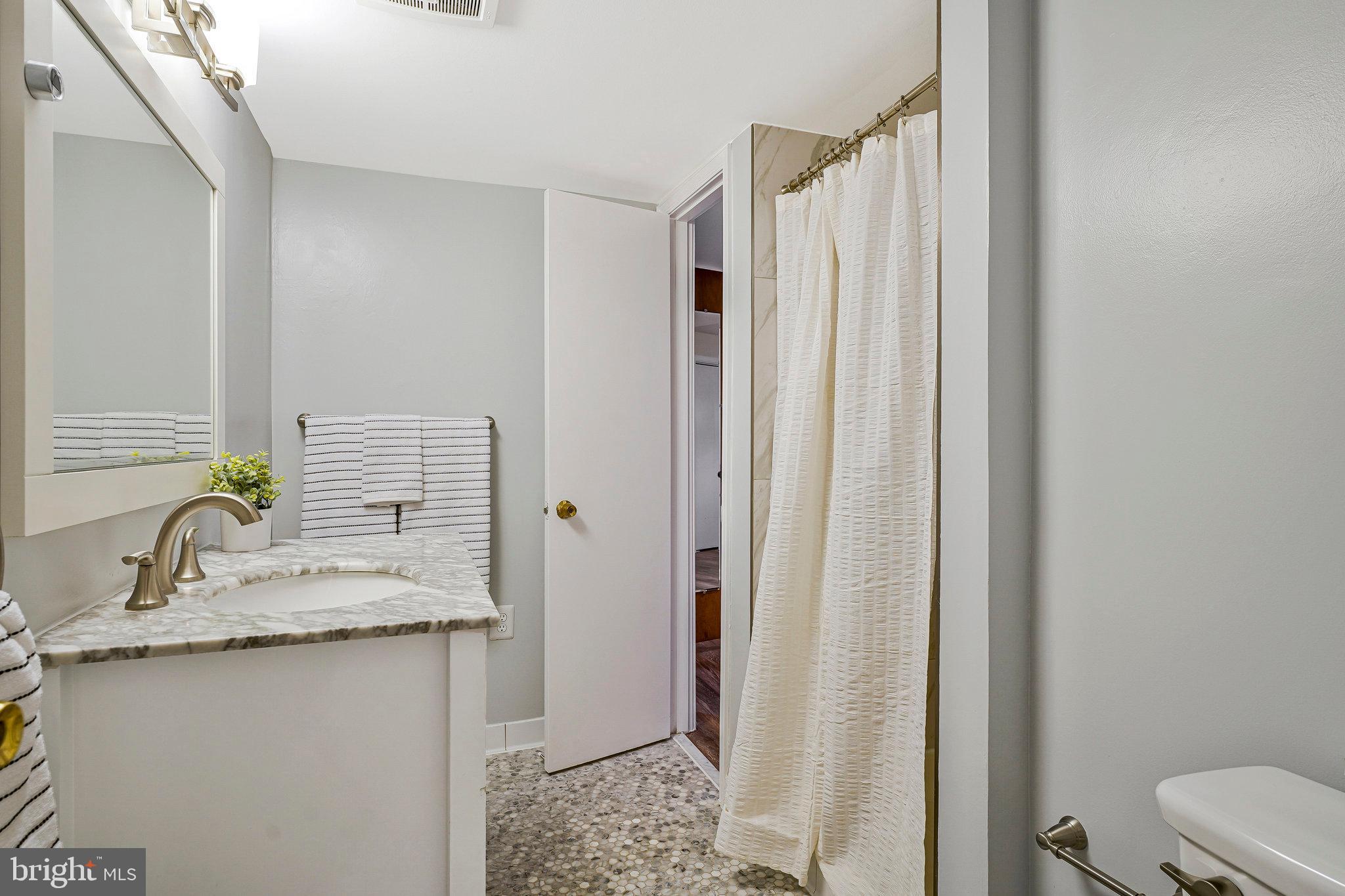 8230 Citadel Place Vienna, VA 22180 - Photo 27 of 38 a bathroom with a granite countertop sink and a mirror