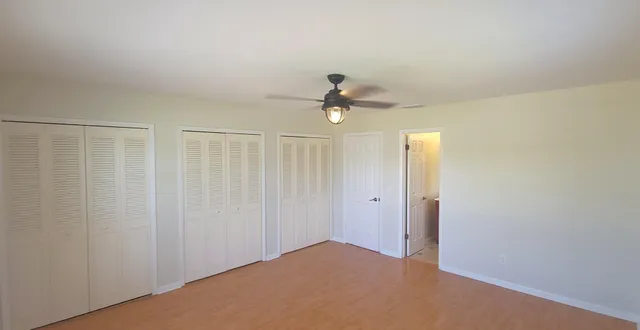 a view of an empty room and a ceiling fan