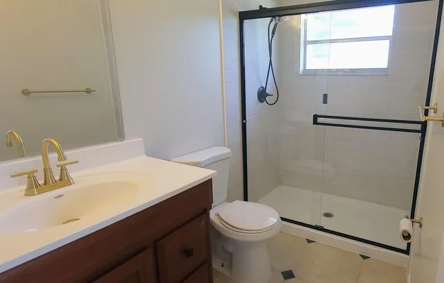 a bathroom with a sink a toilet and shower