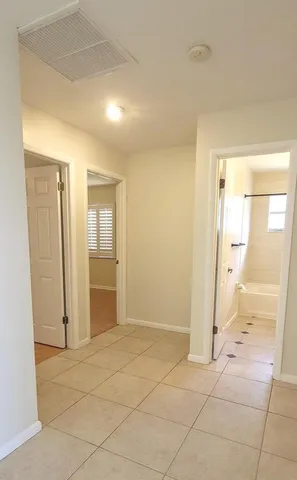 an empty room with a bathroom space and mirror