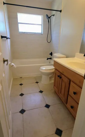 a bathroom with a granite countertop sink a toilet and shower
