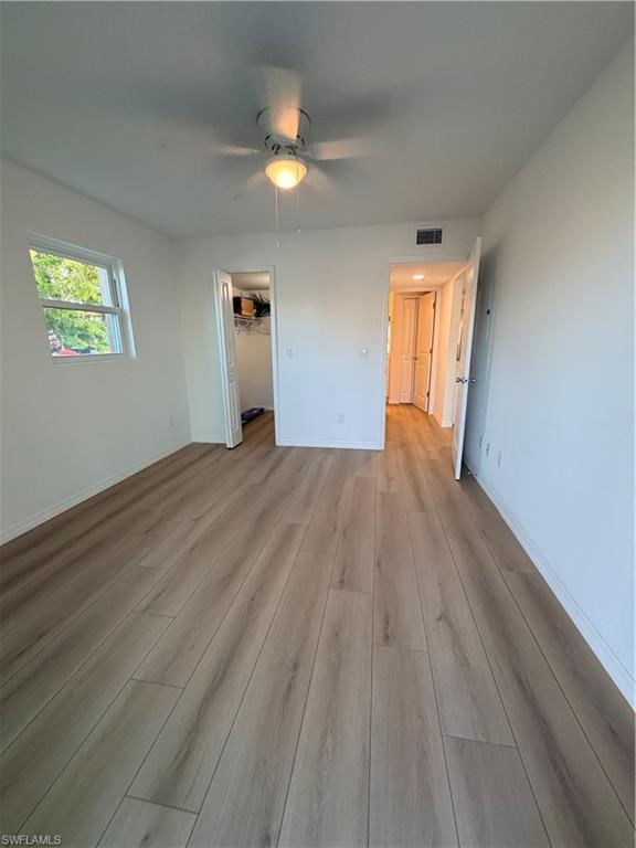 16881 Davis Road, Unit 312 Fort Myers, FL 33908 - Photo 6 of 7 Wood-finish flooring, white walls, ceiling fan with integrated lighting, and a single window