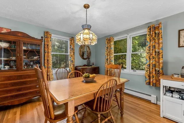 a view of a dining room with furniture a chandelier and wooden floor