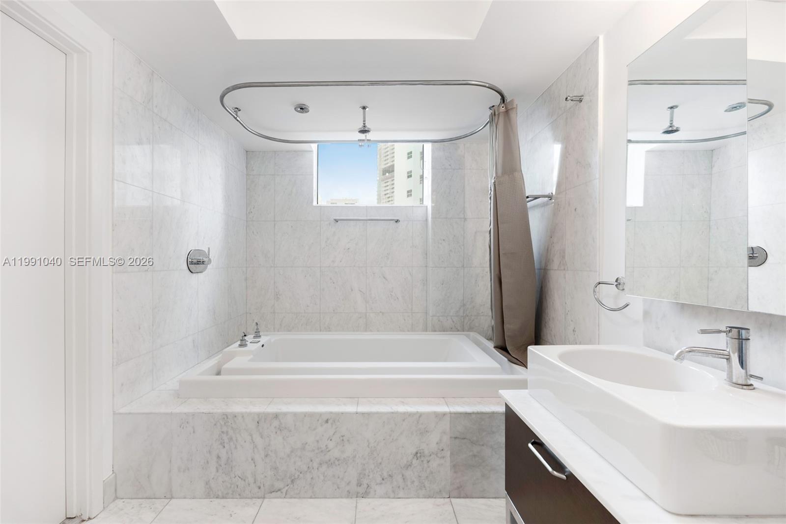 218 Southeast 14th Street, Unit 1007 Miami, FL 33131 - Photo 5 of 32 a bathroom with a tub sink and mirror