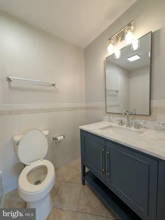 a bathroom with a granite countertop toilet sink and mirror