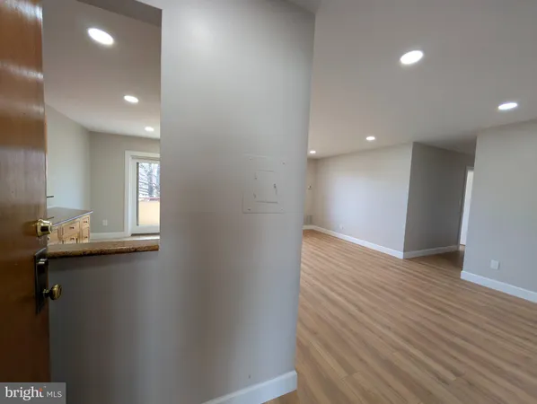 an empty room with wooden floor and mirror