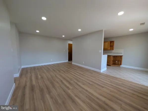 a view of empty room with wooden floor and fireplace