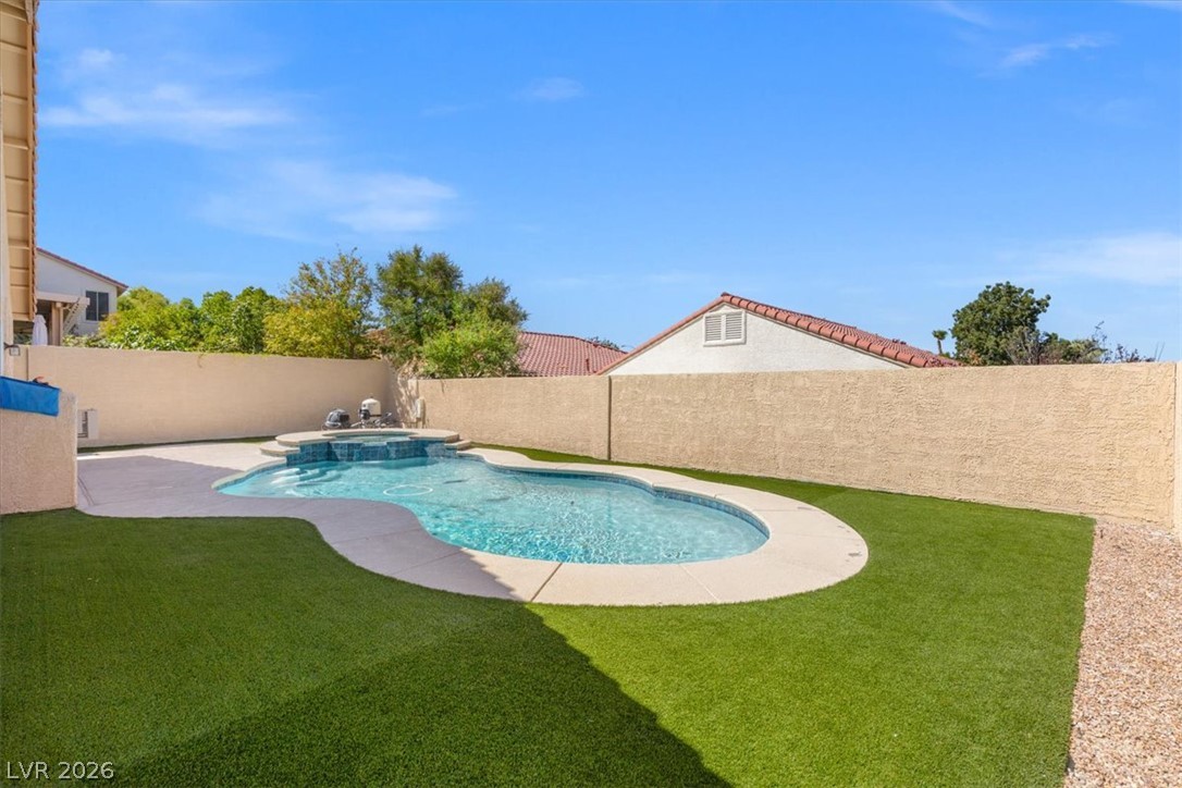 1007 Golden Ridge Court Henderson, NV 89052 - Photo 24 of 27 An inviting backyard oasis features a sparkling custom swimming pool and manicured green turf.