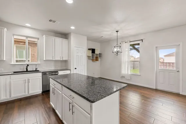 a kitchen with stainless steel appliances granite countertop a stove a sink and a refrigerator