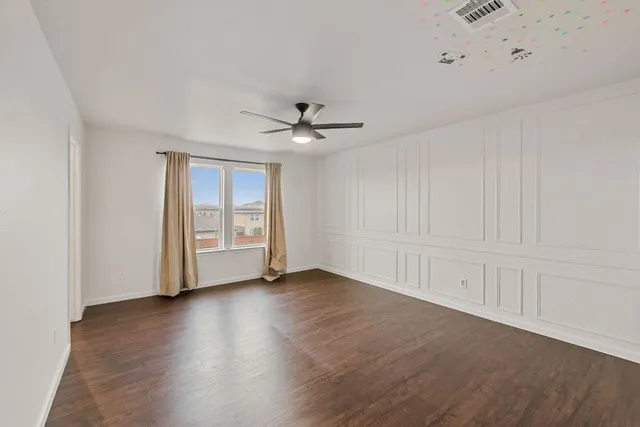 a view of an empty room with wooden floor