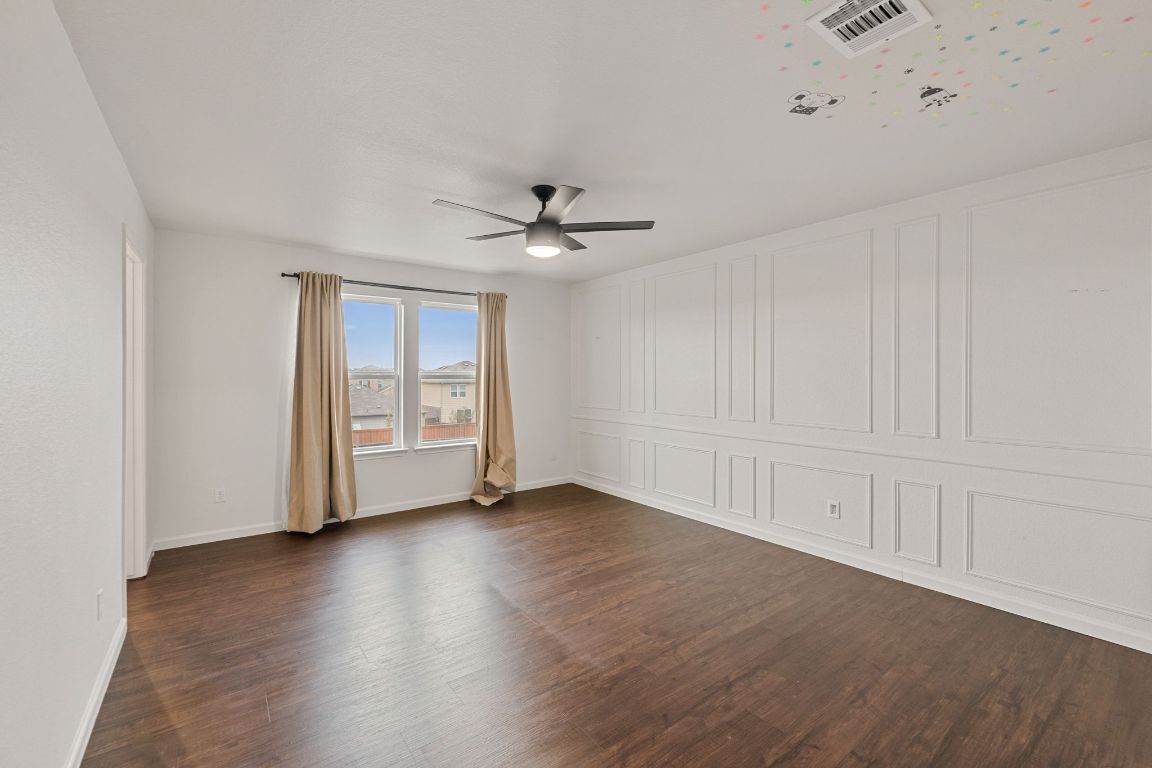 240 Nectar Drive Buda, TX 78610 - Photo 16 of 37 an empty room with wooden floor fan and windows