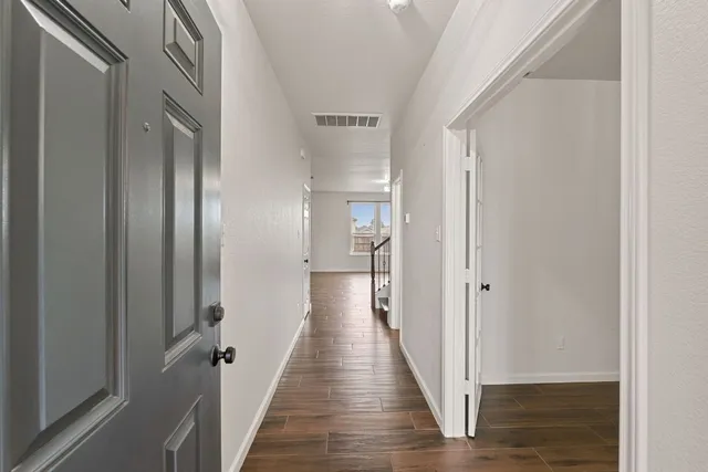 a view of a hallway with wooden floor