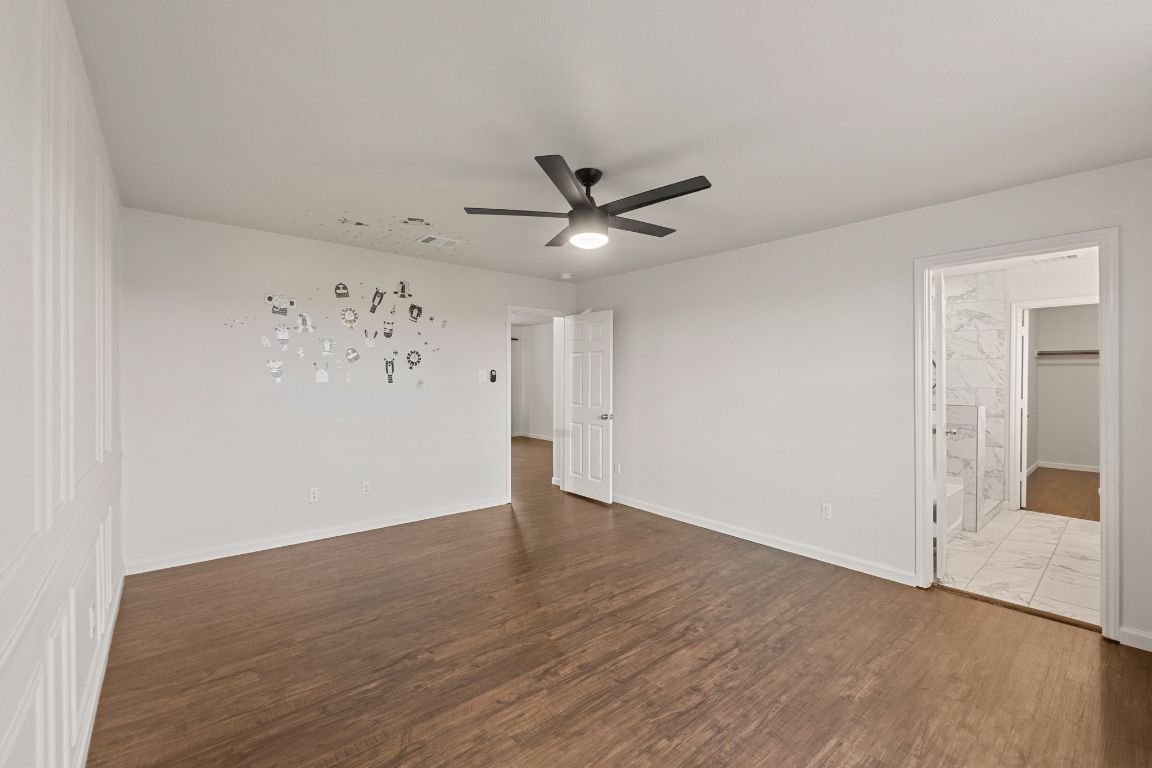 240 Nectar Drive Buda, TX 78610 - Photo 21 of 37 an empty room with wooden floor and ceiling fan