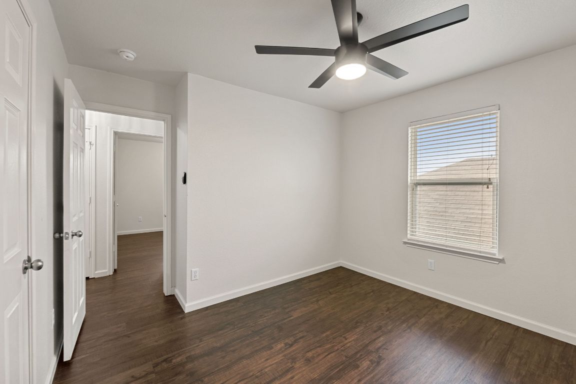 240 Nectar Drive Buda, TX 78610 - Photo 24 of 37 a view of an empty room with wooden floor and a window