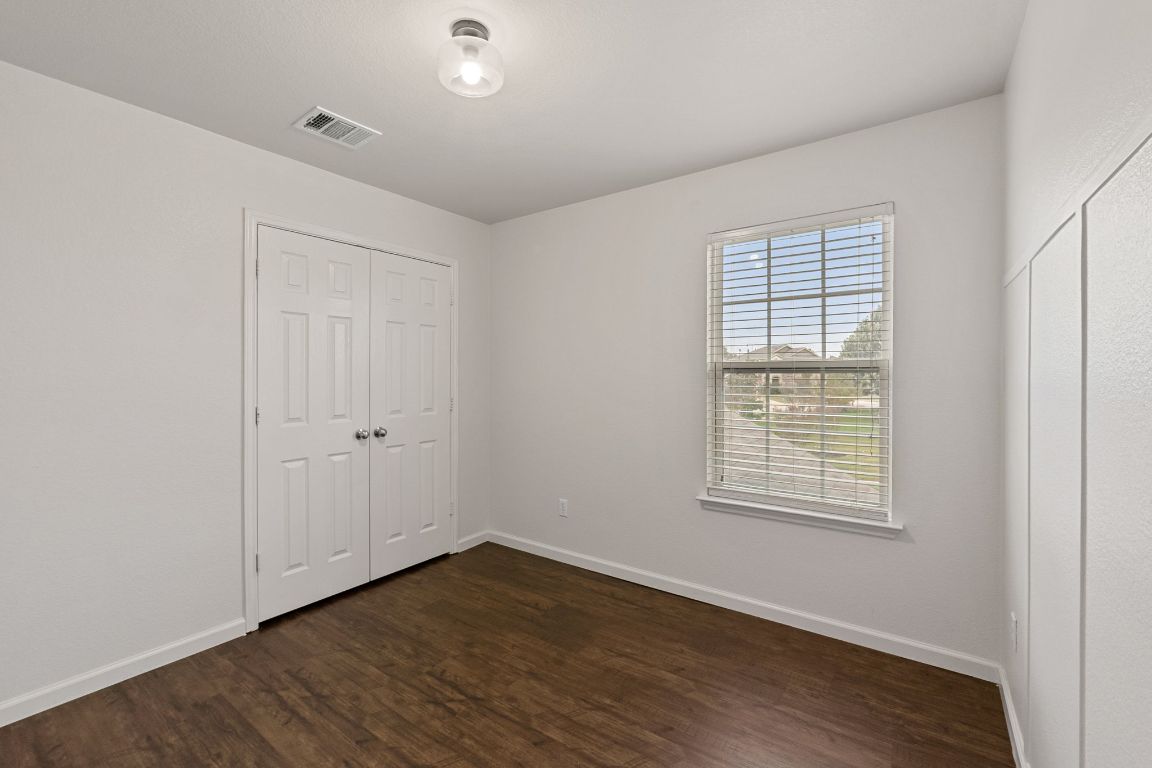 240 Nectar Drive Buda, TX 78610 - Photo 27 of 37 an empty room with wooden floor and windows