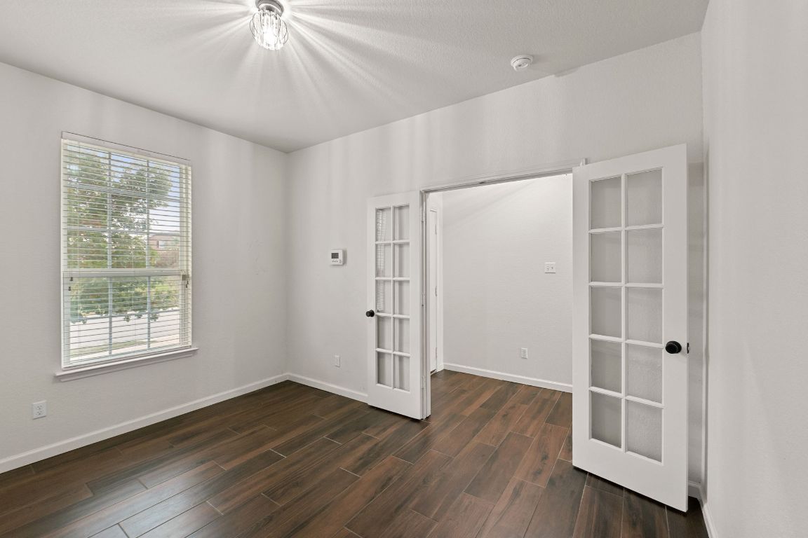 240 Nectar Drive Buda, TX 78610 - Photo 3 of 37 a view of an empty room with wooden floor and a window