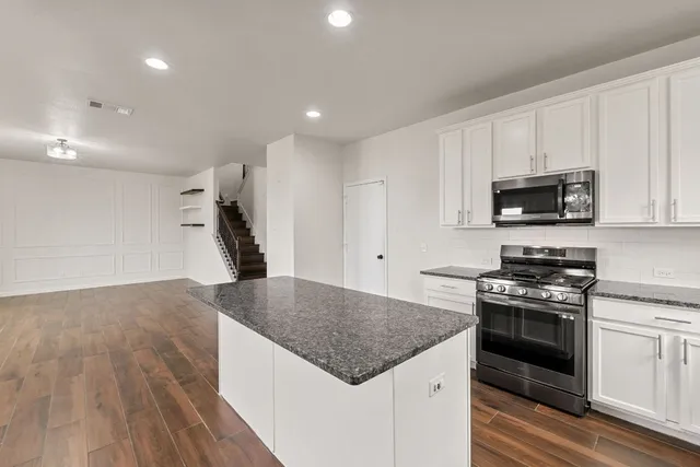a kitchen with granite countertop a stove and a sink