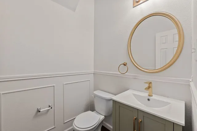 a bathroom with a sink a toilet and a mirror