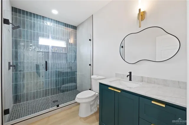a bathroom with a sink a toilet and shower